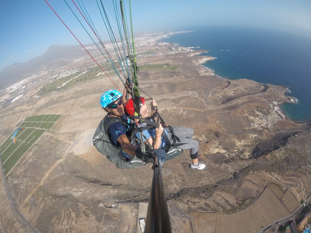 A view of Adele coast, Tenerife from high above, with the pilot and myself floating in the paraglider, sitting in the harnesses.